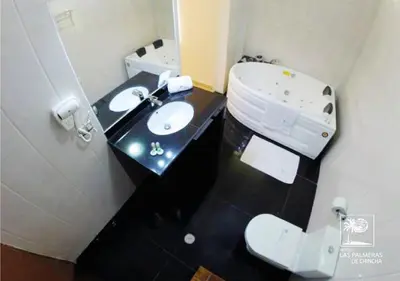 a bathroom with a white toilet and a sink at Qallwa Chincha in Chincha Alta