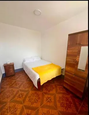 a small bedroom with a bed and a dresser at Casa Límaco in Ayacucho