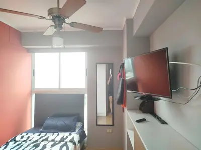 a bedroom with a flat screen tv and a bed at Habitación con baño compartido Santa Catalina in Lima