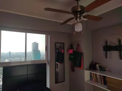 a living room with a ceiling fan and a window at Habitación con baño compartido Santa Catalina in Lima