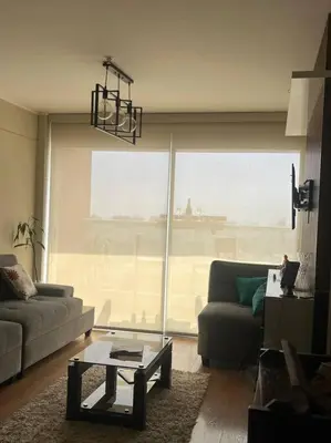 a living room with a couch and a table at Habitación con baño compartido Santa Catalina in Lima