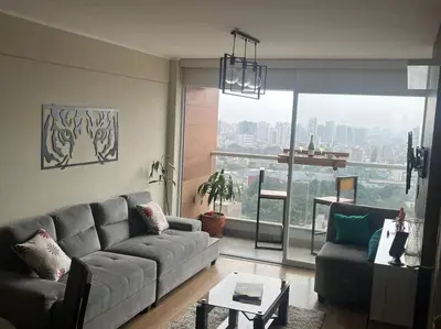 a living room with a couch and a large window at Habitación con baño compartido Santa Catalina in Lima