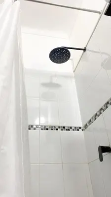 a shower in a bathroom with a shower curtain at 2 beds with garden view and terrace in Lima
