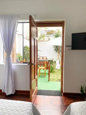 a bedroom with a door open to a patio at 2 beds with garden view and terrace in Lima