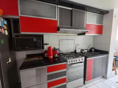 a kitchen with red and white cabinets and a stove at Departamento en Ate in Lima