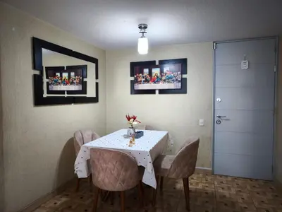 a dining room with a white table and chairs at Departamento en Ate in Lima