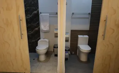 a bathroom with two toilets and two sinks in it at Casa sabina aeropuerto plus in Lima