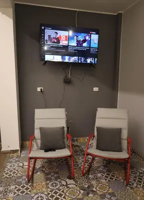 two chairs in a room with a tv on a wall at Casa sabina aeropuerto plus in Lima