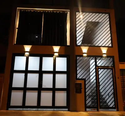 a building with four windows with lights on it at Casa sabina aeropuerto plus in Lima