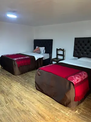a room with two beds with red sheets at Redys House in Cusco