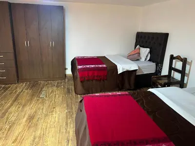 a hotel room with two beds and a dresser at Redys House in Cusco