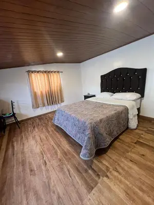 a bedroom with a large bed and a wooden floor at Redys House in Cusco