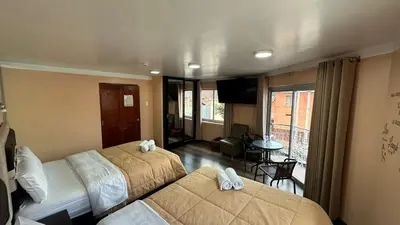 a hotel room with two beds and a balcony at Casa Rustica Hostal Paqcha in Cusco