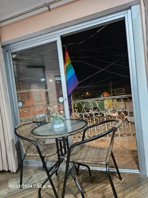 a table and chairs on a balcony with a umbrella at Casa Rustica Hostal Paqcha in Cusco