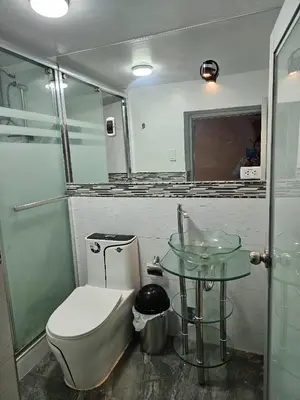 a bathroom with a toilet and a glass table at Casa Rustica Hostal Paqcha in Cusco