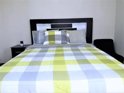 a bedroom with a bed with a checkered blanket at Royalty Inn in Lima