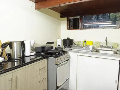 a kitchen with a stove and a sink at Royalty Inn in Lima