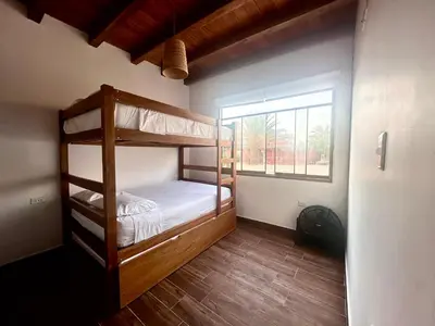 a bedroom with two bunk beds and a window at Refugio del Mar Wakama in San Vicente de Cañete