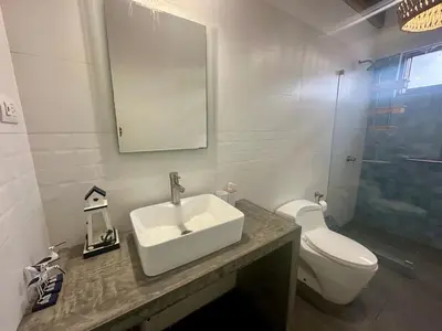 a bathroom with a sink and a toilet and a mirror at Refugio del Mar Wakama in San Vicente de Cañete