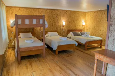 a bedroom with two bunk beds and wooden floors at Cabañitas San José in Oxapampa