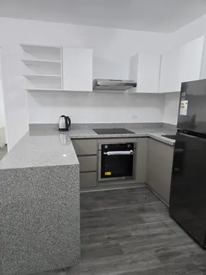 a kitchen with white cabinets and a black appliance at SAM Apartment Cusco in Cusco
