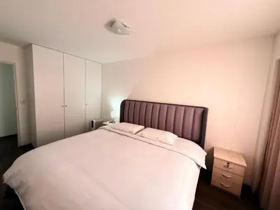 a bedroom with a large white bed with a brown headboard at SAM Apartment Cusco in Cusco