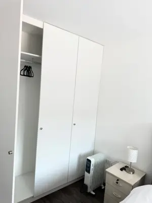 a white bedroom with a large white closet at SAM Apartment Cusco in Cusco