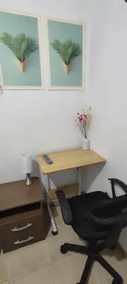 a office with a desk and a chair next to a table at Sumaq Apartment Lima Airport in Lima
