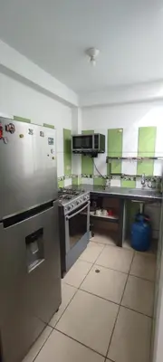 a kitchen with green and white counters and appliances at Sumaq Apartment Lima Airport in Lima