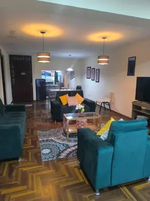 a living room with two couches and a tv at Kusi Wasi in Cusco