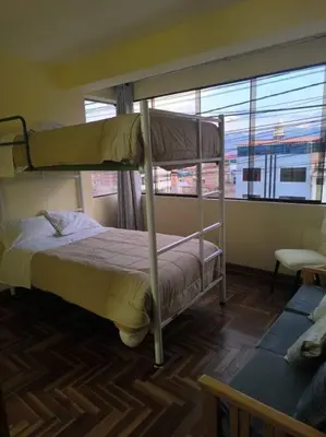 a bedroom with two bunk beds and a window at Kusi Wasi in Cusco