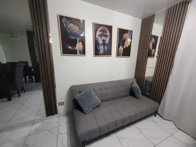 a couch in a room with pictures on the wall at Arleth's hosting in Lima
