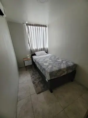 a small bedroom with a bed and a window at Arleth's hosting in Lima