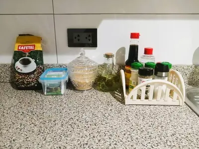 a kitchen counter with spices and bottles on it at Departamento con Cochera in Lima