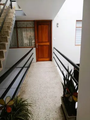 a hallway with a wooden door and a staircase at Departamento con Cochera in Lima