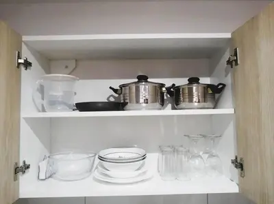 a kitchen shelf with dishes and pots and pans at Departamento con Cochera in Lima