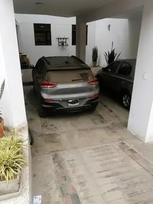a car parked in a garage next to a car at Departamento con Cochera in Lima
