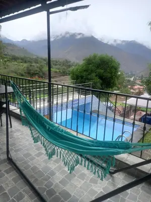 a hammock on a balcony overlooking a swimming pool at CASA DE CAMPO CON PISCINA EN COCACHACRA HUAROCHIRI SOL TODO EL AÑo in Cocachacra
