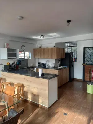 a kitchen with wooden cabinets and a counter top at CASA DE CAMPO CON PISCINA EN COCACHACRA HUAROCHIRI SOL TODO EL AÑo in Cocachacra