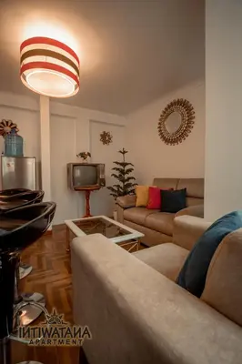 a living room with a couch and a tv at Intiwatana Apartment in Cusco