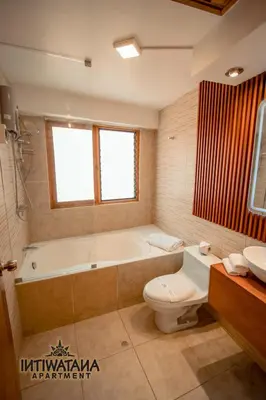 a bathroom with a tub and a toilet and a sink at Intiwatana Apartment in Cusco