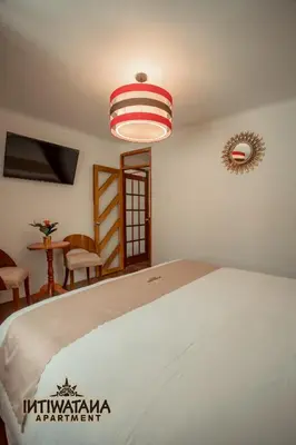 a bedroom with a bed with a white bedspread at Intiwatana Apartment in Cusco