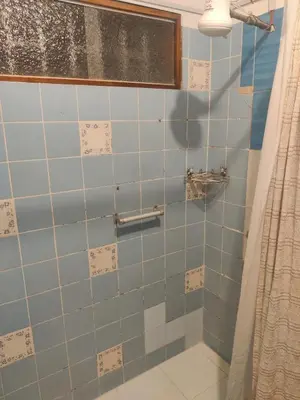 a bathroom with a shower with blue tiles at bungalows in Santa Rosa