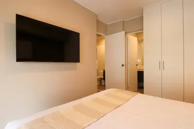 a bedroom with a bed with a flat screen tv on the wall at Vital by Wynwood House in Lima