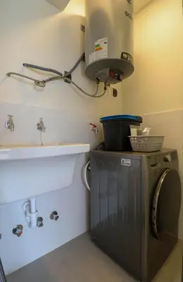 a kitchen with a sink and a washing machine at Aquilaria by Wynwood House in Lima