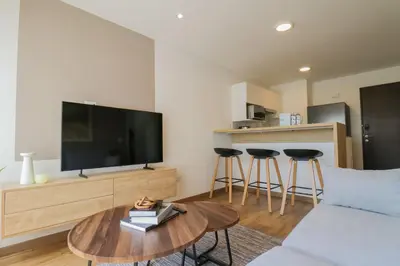 a living room with a couch and a tv and a table at Aquilaria by Wynwood House in Lima