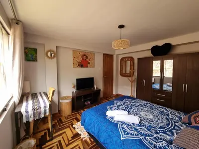 a bedroom with a blue bed and a television at boutique guest house art in the center of cusco in Cusco