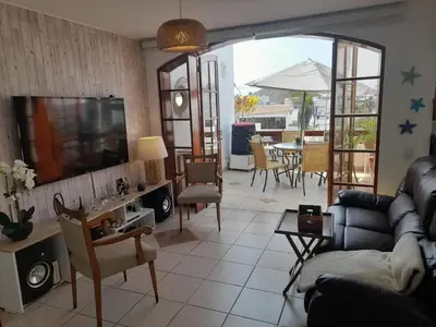a living room with a couch and a tv and a table at Hogar de Jorge y Mary PLAYA SANTA MARÍA DEL MAR in Quebrada Seca