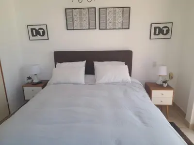 a bedroom with a large bed with two night stands at Hogar de Jorge y Mary PLAYA SANTA MARÍA DEL MAR in Quebrada Seca