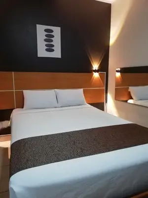 a bedroom with a large white bed in a room at Hotel Villa Capricce in Puente Piedra
